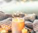 "luxury burning holiday candle with knitted scarf on wooden table"
